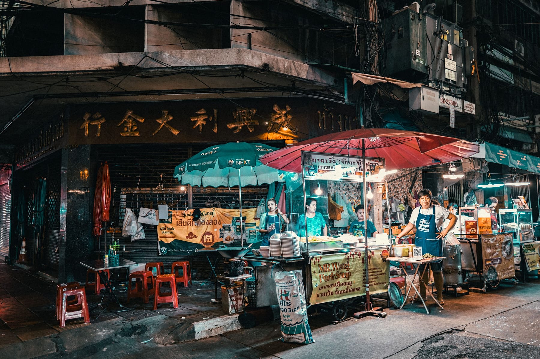 Street food vendors and stalls on a busy Bangkok market street